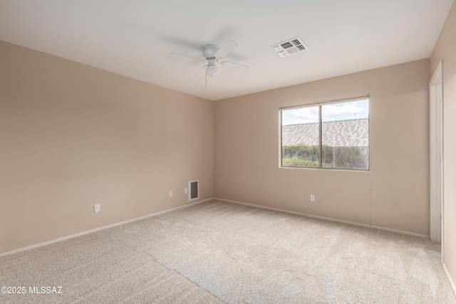 carpeted empty room with visible vents, ceiling fan, and baseboards