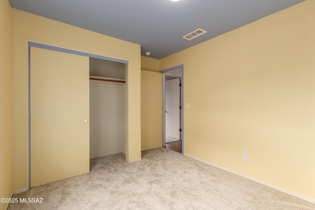 unfurnished bedroom featuring carpet, a closet, and visible vents