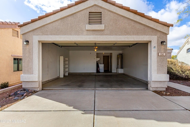 garage with a garage door opener, water heater, and driveway