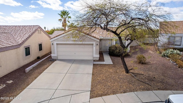 view of front of house with driveway, an attached garage, a tile roof, and stucco siding