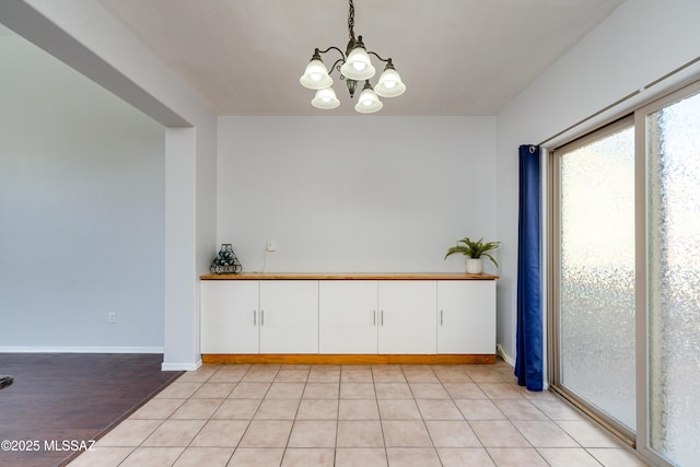 interior space with a chandelier and baseboards