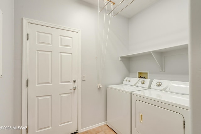 laundry room featuring light tile patterned floors, laundry area, washing machine and clothes dryer, and baseboards