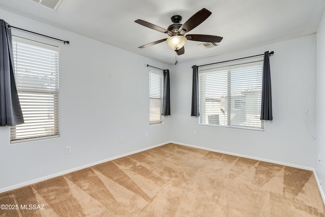 unfurnished room featuring carpet flooring, ceiling fan, visible vents, and baseboards