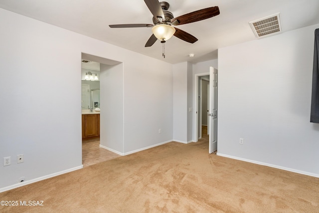 spare room featuring a ceiling fan, visible vents, light carpet, and baseboards