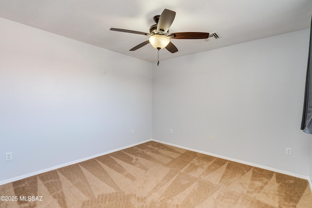 spare room with carpet floors, visible vents, baseboards, and a ceiling fan