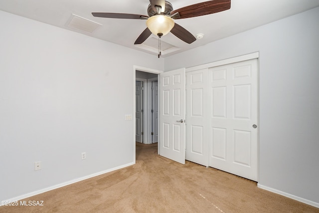 unfurnished bedroom featuring a closet, light colored carpet, visible vents, a ceiling fan, and baseboards