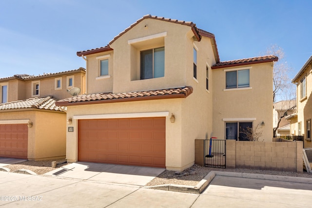 mediterranean / spanish house with concrete driveway, fence, and stucco siding