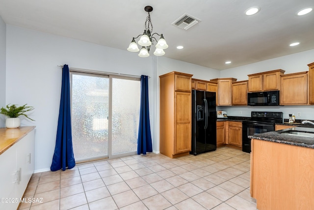 kitchen with visible vents, brown cabinetry, a sink, dark stone counters, and black appliances