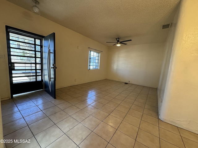 entrance foyer with a ceiling fan, visible vents, a textured ceiling, and light tile patterned floors