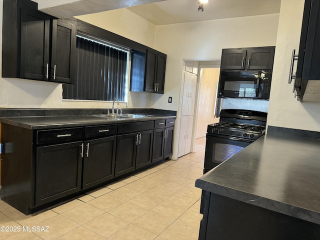 kitchen with dark cabinets, dark countertops, a sink, and black appliances