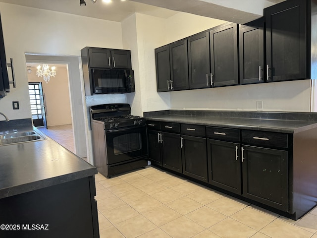 kitchen with dark countertops, black appliances, dark cabinetry, and a sink