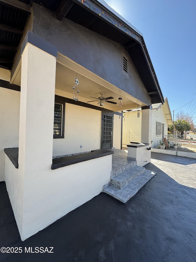 exterior space with ceiling fan, a patio area, fence, and stucco siding