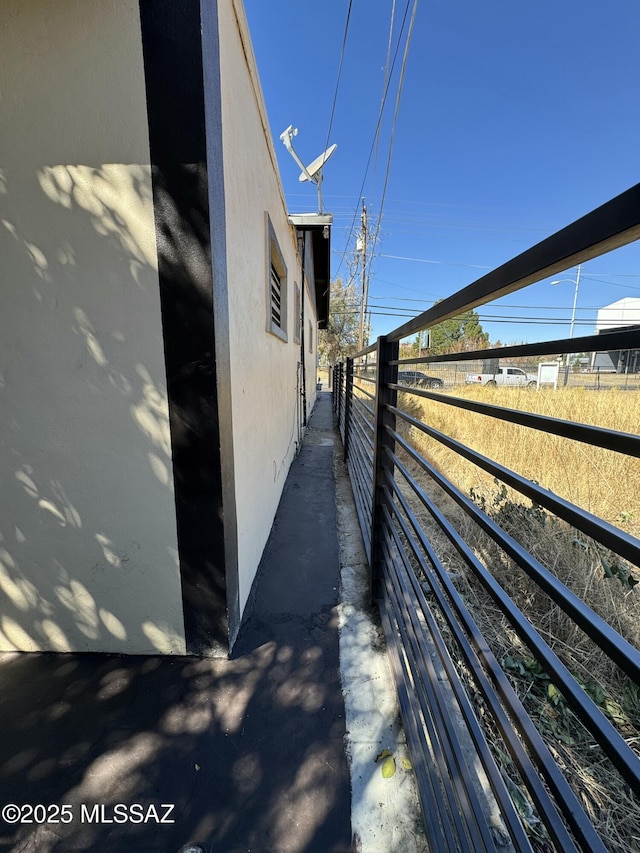 view of side of home featuring fence and stucco siding