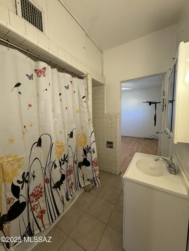 full bathroom featuring visible vents, a shower with curtain, tile patterned floors, vanity, and tile walls