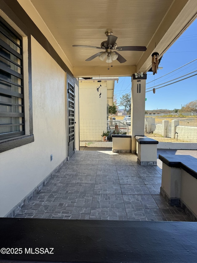 view of patio / terrace with fence and a ceiling fan