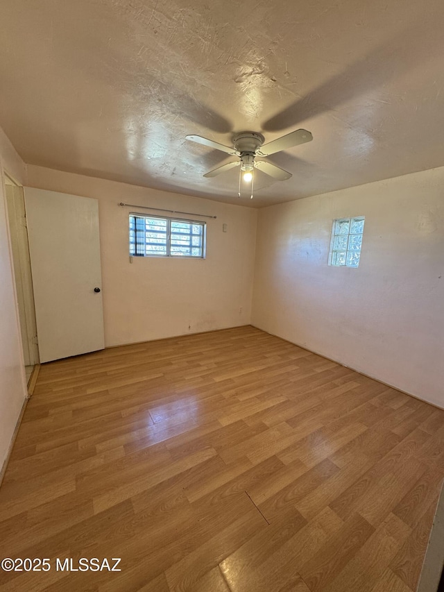 spare room featuring ceiling fan, a textured ceiling, and light wood-style flooring