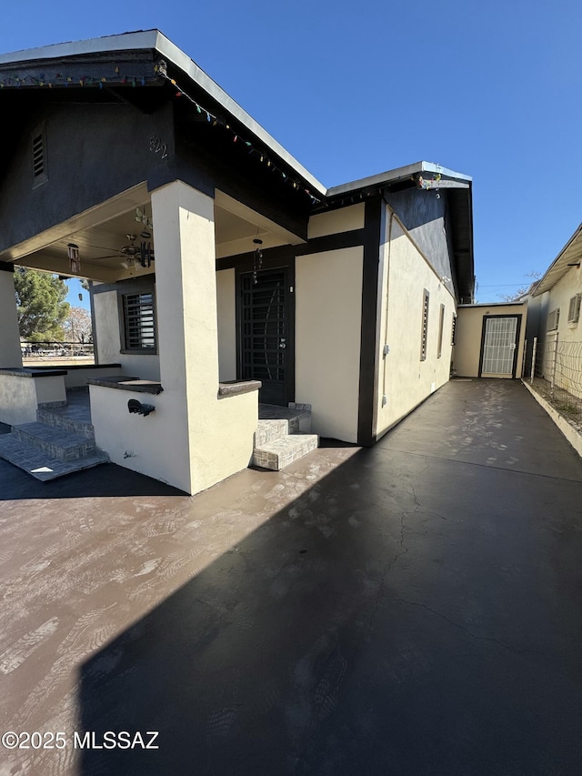 back of property featuring a patio area, a ceiling fan, and stucco siding