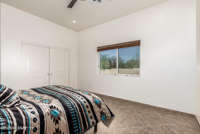 bedroom featuring a closet, visible vents, a ceiling fan, tile patterned flooring, and baseboards