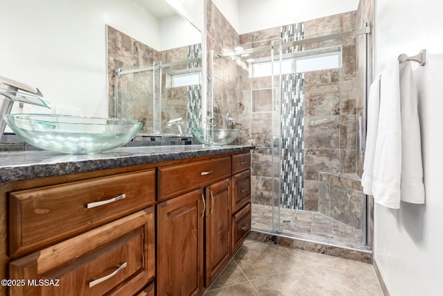 bathroom featuring a wealth of natural light, a stall shower, a sink, and double vanity