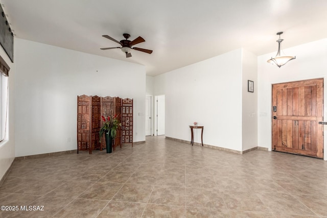 unfurnished living room with ceiling fan and baseboards