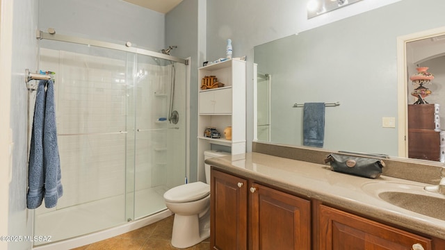 bathroom featuring toilet, a shower stall, vanity, and tile patterned floors