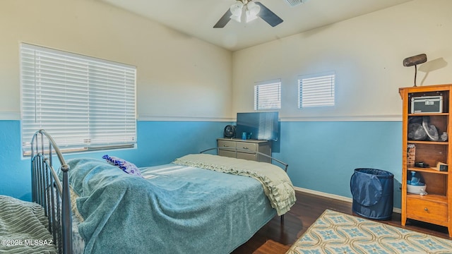 bedroom featuring visible vents, dark wood finished floors, baseboards, and ceiling fan