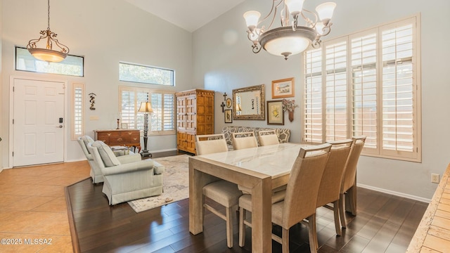 dining room with a high ceiling, wood finished floors, and baseboards