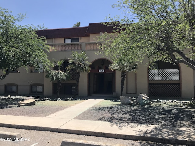 view of front of home with a balcony and stucco siding