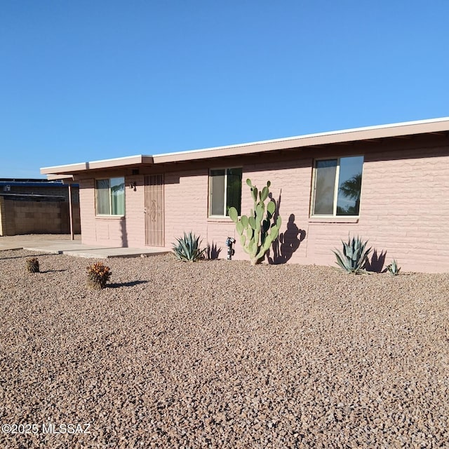 view of front of house featuring a patio and brick siding