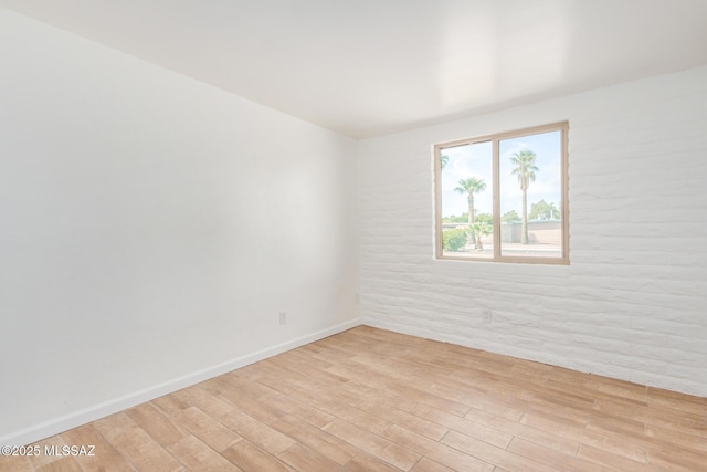 unfurnished room with baseboards and light wood-style flooring