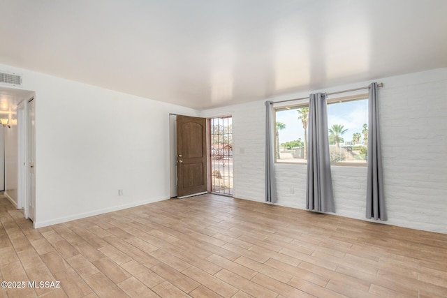 unfurnished room featuring visible vents and light wood-type flooring