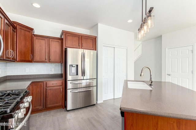 kitchen featuring dark countertops, tasteful backsplash, appliances with stainless steel finishes, and a sink