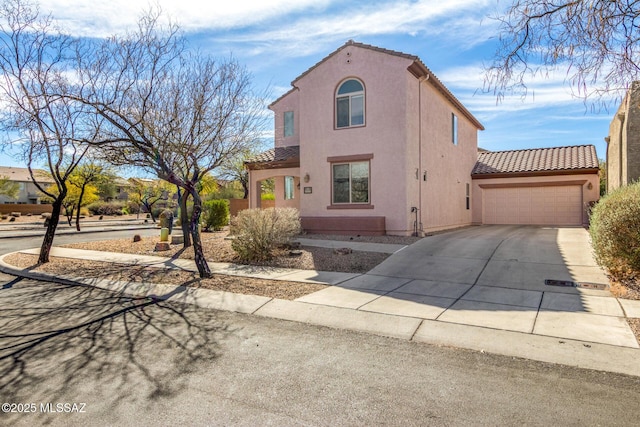 mediterranean / spanish-style house with concrete driveway, a tile roof, an attached garage, and stucco siding