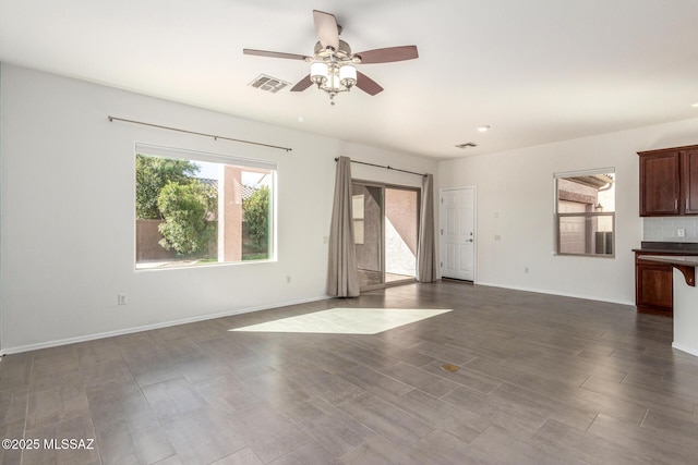 unfurnished living room featuring ceiling fan, dark wood-style flooring, visible vents, and baseboards