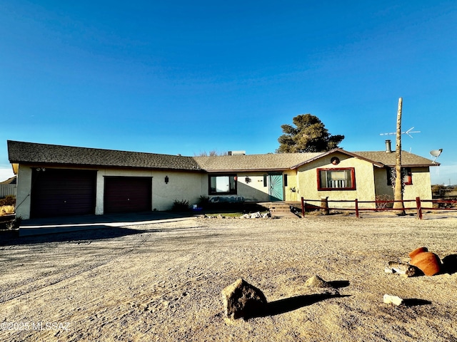 ranch-style home featuring a garage, driveway, and fence