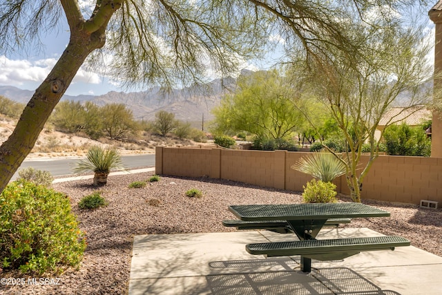 view of patio / terrace with a mountain view, fence, and visible vents