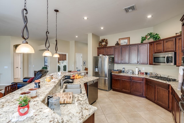 kitchen featuring independent washer and dryer, stainless steel appliances, a sink, light tile patterned flooring, and visible vents