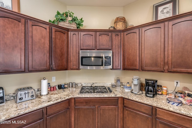 kitchen featuring light stone countertops and stainless steel appliances