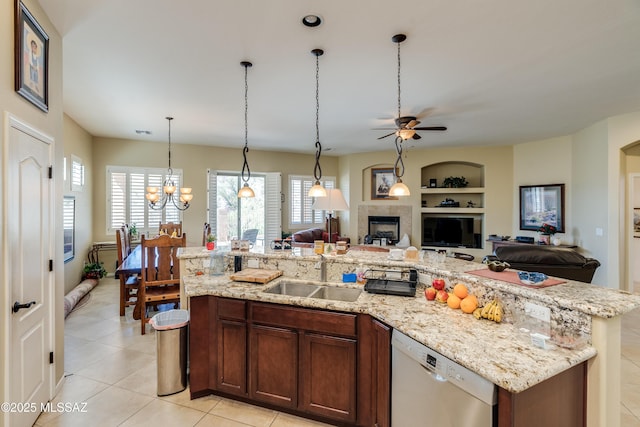kitchen featuring open floor plan, ceiling fan with notable chandelier, a sink, dishwasher, and built in features