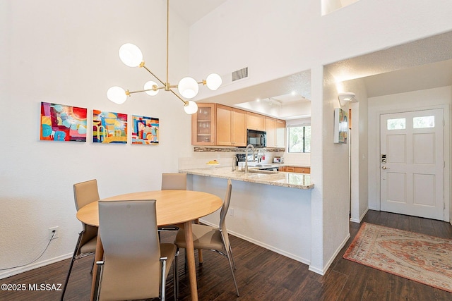 dining space featuring dark wood-type flooring, visible vents, and baseboards