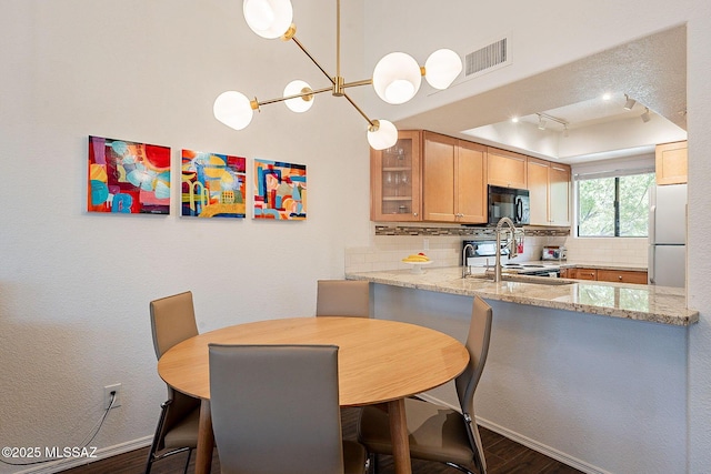 kitchen with white appliances, visible vents, decorative backsplash, a tray ceiling, and glass insert cabinets