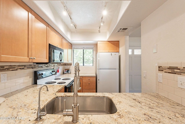 kitchen with electric stove, visible vents, freestanding refrigerator, a sink, and black microwave