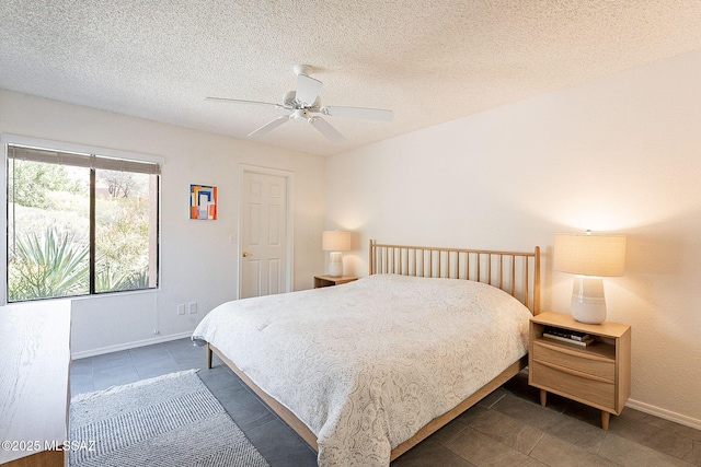 bedroom with a textured ceiling, a ceiling fan, and baseboards