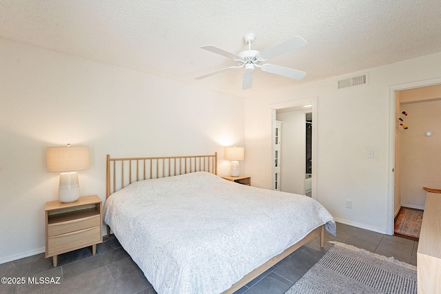 bedroom featuring a textured ceiling, baseboards, visible vents, and a ceiling fan