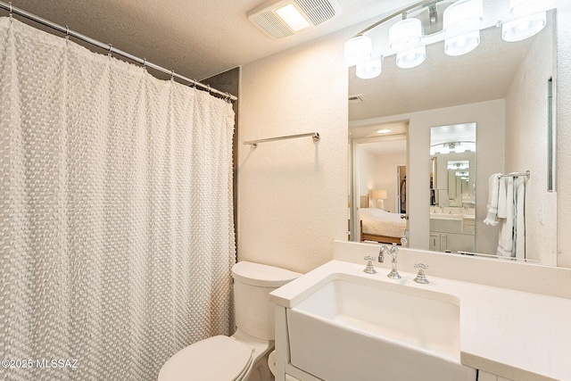 full bath featuring ensuite bathroom, a textured wall, a textured ceiling, toilet, and visible vents