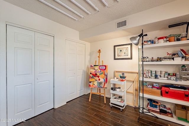 interior space featuring dark wood-style floors, visible vents, and a textured ceiling