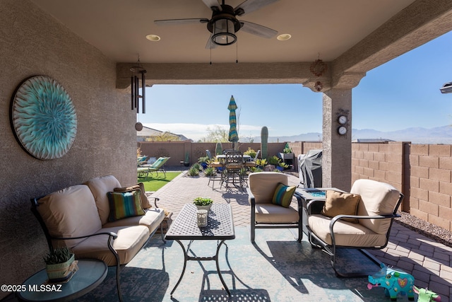 view of patio featuring a fenced backyard, outdoor lounge area, a ceiling fan, and outdoor dining space