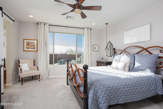 bedroom with recessed lighting, visible vents, a barn door, light carpet, and baseboards