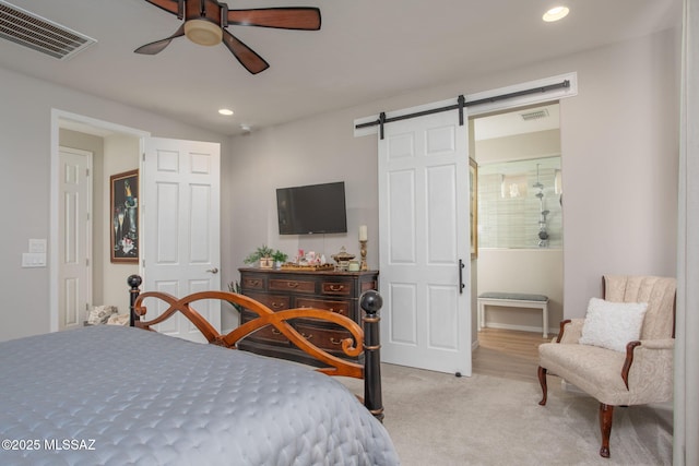 bedroom with a barn door, carpet, visible vents, and recessed lighting