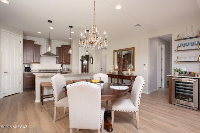 dining room featuring recessed lighting, beverage cooler, visible vents, light wood-type flooring, and a bar